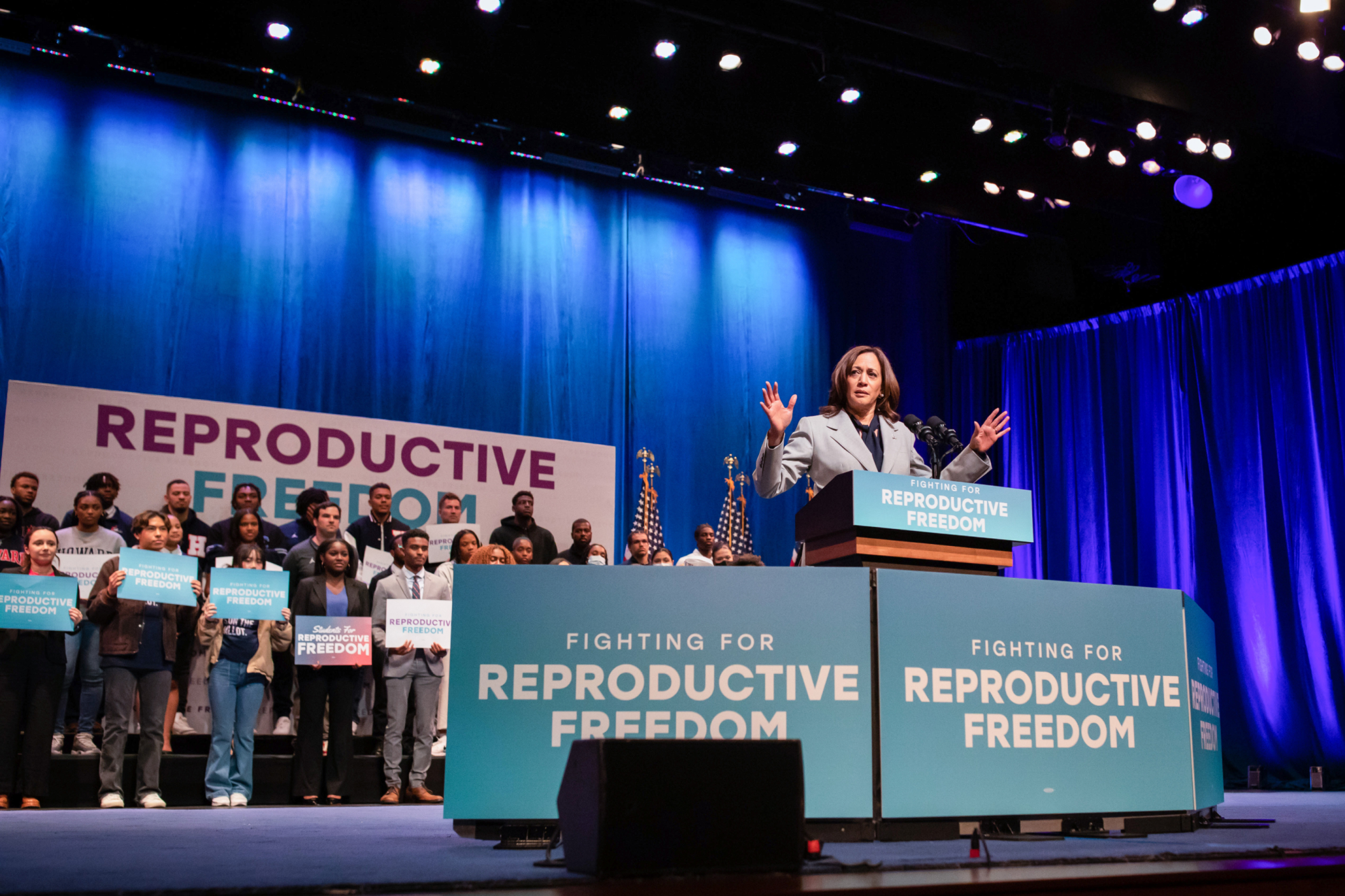 Vice President Harris addressing an audience with signs that say "Fighting for Reproductive Freedom"